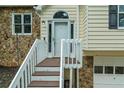 Close-up view of the front entrance with stone accents, white railing, and front door at 5640 Rolling Oaks Dr, Cumming, GA 30040