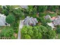 Stunning aerial view of the home with mature trees, a driveway, and well-maintained landscaping at 4645 Waterford Dr, Suwanee, GA 30024