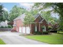 Beautiful brick home featuring a three-car garage and well-maintained landscaping at 4645 Waterford Dr, Suwanee, GA 30024