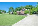 Spacious property with a large front yard, long driveway, and a well-maintained lawn and garden at 7045 Grand View Way, Suwanee, GA 30024