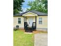 Charming home featuring a welcoming front porch and well-maintained lawn at 1357 Railroad Ave, Sugar Hill, GA 30518