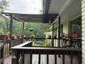 Inviting covered porch area with wood railing, open beam pergola, and cozy seating at 3291 Shady Oak Dr, Atlanta, GA 30340