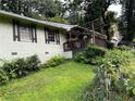 Ranch-style home with a wooden pergola-covered porch and lush landscaping, creating a serene outdoor space at 3291 Shady Oak Dr, Atlanta, GA 30340