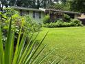 Ranch-style home featuring a lush lawn and mature trees, complemented by a charming pergola-covered porch at 3291 Shady Oak Dr, Atlanta, GA 30340