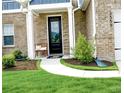 Inviting entryway with manicured landscaping and a charming bench on the walkway leading to the front door at 3855 Saddle Bag Ct, Dacula, GA 30019