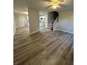Spacious living room featuring modern flooring, ceiling fan, and staircase access at 4510 Burks Rd, Forest Park, GA 30297