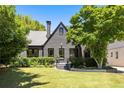 Attractive two-story home features a dark exterior, manicured lawn, and beautiful trees at 570 Martina Ne Dr, Atlanta, GA 30305