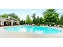 Large community pool with lounge chairs and a covered pavilion surrounded by trees at 779 Avonley Creek Trce, Sugar Hill, GA 30518