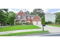 Traditional two-story brick home with well-kept lawn and a two-car garage at 779 Avonley Creek Trce, Sugar Hill, GA 30518