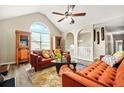 Bright living room featuring vaulted ceilings, modern furniture, laminate floors, and large windows for ample natural light at 11072 Pebble Ridge Dr, Hampton, GA 30228