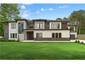 Beautifully landscaped home with lush green grass, modern design, and a combination of brick, white, and wood exterior finishes at 2709 Collins Hill Rd, Lawrenceville, GA 30043