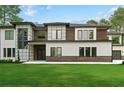 Stunning home showcasing a modern exterior with mixed materials and lush green lawn, perfect for upscale living at 2709 Collins Hill Rd, Lawrenceville, GA 30043