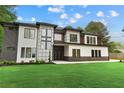 Modern home with a well-manicured lawn, a striking mix of materials on the facade, and stylish architectural details at 2709 Collins Hill Rd, Lawrenceville, GA 30043
