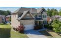 Well-maintained two-story home showcases a beautiful brick facade and a spacious two-car garage on a lush green lawn at 3259 Ivy Crossing Dr, Buford, GA 30519