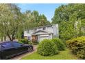 Inviting two-story home featuring an attached garage, mature landscaping, and a private driveway at 4256 Village Square Ln, Stone Mountain, GA 30083