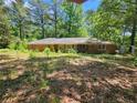 One-story brick home on a large lot with mature trees, exuding a natural charm at 225 Oglesby Bridge Rd Se, Conyers, GA 30094