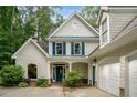 Charming two-story home featuring blue shutters, white siding, and an attached two car garage at 2709 Windrush Dr, Buford, GA 30518