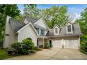 Charming two-story home featuring blue shutters, white siding, and an attached two car garage at 2709 Windrush Dr, Buford, GA 30518