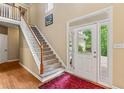 Bright foyer with hardwood floors, staircase, and a front door with sidelights at 2709 Windrush Dr, Buford, GA 30518