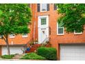 Classic brick townhome with a private entrance, manicured landscaping, and attached garage at 3833 Savannah E Sq, Atlanta, GA 30340