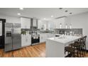 Modern kitchen with white cabinets, stainless steel appliances, and breakfast bar seating at 4041 Blanton Sw Ave, Atlanta, GA 30331