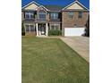 Two story brick home featuring a well manicured front yard and attached two car garage at 5030 Mundy Dr, Cumming, GA 30028