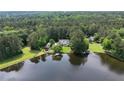 Aerial view of a lakeside home surrounded by lush greenery, featuring a private dock and serene water views at 625 W Lake Dr, Oxford, GA 30054