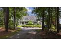 Beautiful home framed by mature trees, featuring a welcoming front porch and a driveway leading to a peaceful retreat at 625 W Lake Dr, Oxford, GA 30054