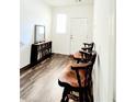 Bright foyer features wood-look flooring, a bookshelf, and a view of the front door at 6408 Kennonbriar Ct, Lithonia, GA 30058