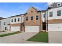 Charming new construction townhomes with brick and siding, featuring individual garages at 8210 Tiger Way, Riverdale, GA 30296