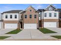 Modern townhomes with brick and siding exteriors, individual garages and professional landscaping at 8210 Tiger Way, Riverdale, GA 30296