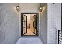 Elegant black framed glass double doors surrounded by gray brick, showcasing a modern entrance at 2110 Fairway Ne Cir, Brookhaven, GA 30319