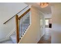 Bright entryway with decorative light fixture, staircase with wood and iron railing and luxury vinyl plank flooring at 3263 Long Iron Pl, Lawrenceville, GA 30044