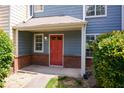 Close-up of the front entrance showing red front door and brick accent with lush bushes at 3263 Long Iron Pl, Lawrenceville, GA 30044