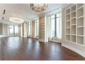 Expansive living room with hardwood floors, built-in shelving, and elegant chandelier lighting at 3376 Peachtree Ne Rd # 35A, Atlanta, GA 30326