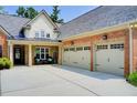 Exterior showcasing a brick home with attached two-car garage and manicured yard at 5220 Wild Cedar Dr, Buford, GA 30518