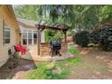 Stone outdoor kitchen with a built-in grill and seating area in backyard at 5220 Wild Cedar Dr, Buford, GA 30518
