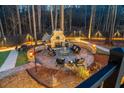 Inviting outdoor space with a stone fireplace, seating, and ambient lighting for cozy evenings at 149 Avalon Way, Sharpsburg, GA 30277