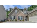 Attractive exterior showcasing a brick accent, complemented by a manicured lawn and a two-car garage at 2842 Sedgeview Ln, Buford, GA 30519