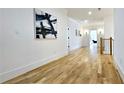 Hallway featuring hardwood floors, white walls, and modern artwork at 1102 Morley Se Ave, Atlanta, GA 30312
