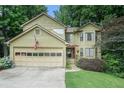 Charming two-story home featuring a two-car garage, lush landscaping, and a welcoming front entrance at 265 Lee River Cv, Suwanee, GA 30024