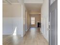 Bright foyer with wood-look flooring, decorative wainscoting, and view of the fireplace at 124 Felicity Pike, Locust Grove, GA 30248