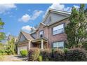 A two-story brick home featuring gray siding accents, a covered porch, and mature landscaping at 4889 Arbor View Nw Pkwy, Acworth, GA 30101