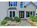 Close up of front entrance with double doors, decorative rock landscaping, and window awnings at 9440 Knollcrest Blvd, Alpharetta, GA 30022