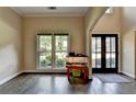 View of the living room displaying gleaming hardwood floors, large windows, and a high ceiling at 9440 Knollcrest Blvd, Alpharetta, GA 30022