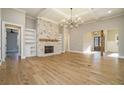 Spacious living room with stone fireplace, built-in bookshelves, coffered ceiling, modern chandelier, and gleaming hardwood floors at 2200 Upper Burris Rd, Canton, GA 30114