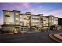 Exterior of a modern apartment building featuring stone accents, balconies, and covered parking at 3351 Orwell Way # 2305, Cumming, GA 30041