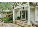 A covered entryway with stone steps leads to double doors framed by white columns and greenery at 5251 Powers Ferry Rd, Atlanta, GA 30327