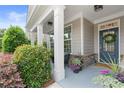 Inviting front porch with decorative columns, seasonal plants, and a charming front door with wreath at 519 Rosemont Ave, Canton, GA 30115