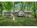 Backyard view of home with a small deck perfect for outdoor enjoyment and serene nature views at 5837 Fox Run, Rex, GA 30273